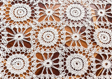 Antique white lace on wooden background