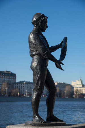 Moscow, Russia, March 25, 2020: Boy with fish sculpture in cascade in Neskuchny Garden on Moscow River backgroundのeditorial素材