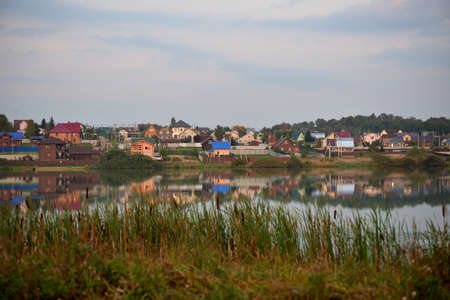View of village Vasilievskoye on banks of Imbushka river on sunny autumn day, Sergiev Posad district, Moscow region, Russiaの写真素材