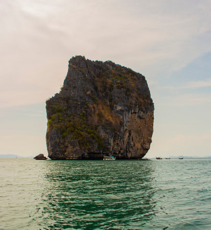 At Krabi, Thailand, a view of a rock mountain in the Andaman Sea with sky and clouds in the background.の写真素材