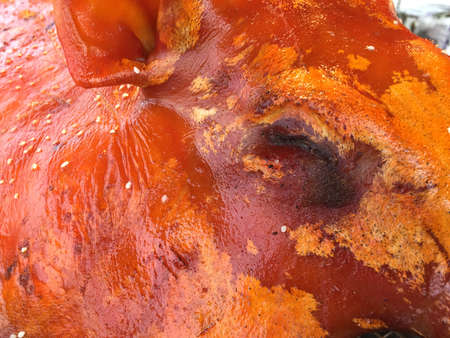 Close-up of a grilled suckling pig's eye on the roaster in the kitchen room.