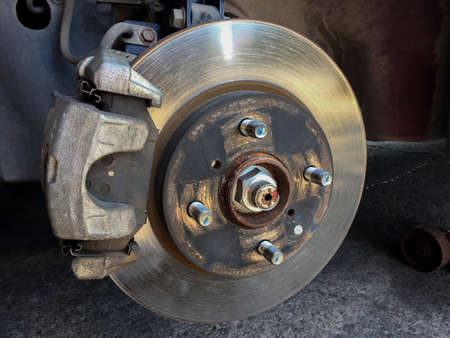 Close-up of the vehicle's disc brake in the garage for maintenance. Repairing the car's disc brake.の写真素材