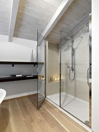 shower cubicle in a modern bathroom on attic with wood ceiling nd parquetの写真素材