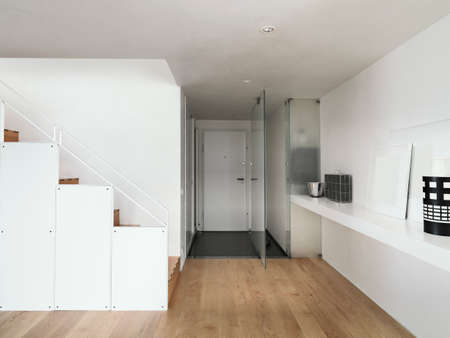 detail of the  entrance of a modern apartment in foreground the staircase and wood floorの写真素材