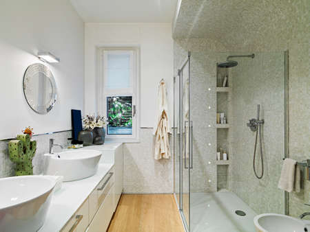 interior view of a modern bathroom with glass shower cubicle and wood floorの写真素材