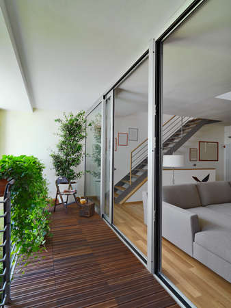 balcony with wood floor overlooking on the modern living room and staircaseの写真素材