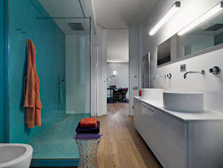 internal view of a modern bathroom with two countertop weshvasin with shower cubicle and wooden floorの写真素材