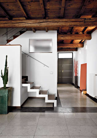 interiors shots of a modern living room in the foreground the staircase and the wooden ceiling in the botom the main doorの写真素材