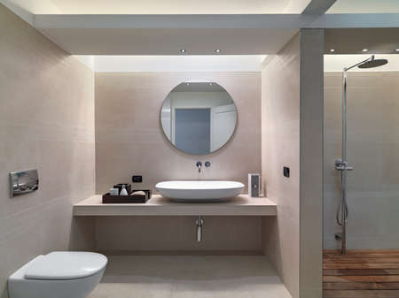 interior view of a modern bathroom in foreground the countertop washbasin wohse walls are coated of pink marble overlooking on the shower cubicleの写真素材