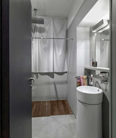 interior of a modern bathroom in the foreground the column washbasin on the background the masonry shower box with glass doorの写真素材