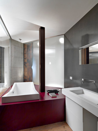modern bathroom interior with wooden floor in the foreground the bathtub on the right the wall mounted washbasin with the mirrorの写真素材