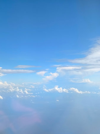 clouds in the blue sky as seen through window of an aircraftの写真素材