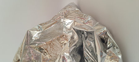 Crumpled aluminum foil on a white background, close-upの写真素材