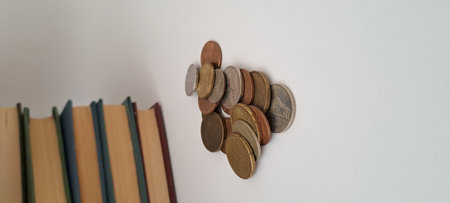 Coins and books on a white background. Concept of saving money