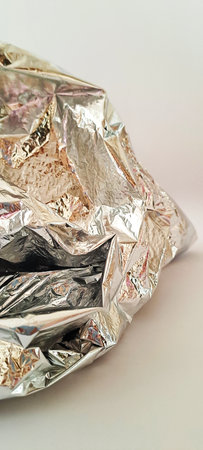 Crumpled aluminum foil on a white background. Close up.