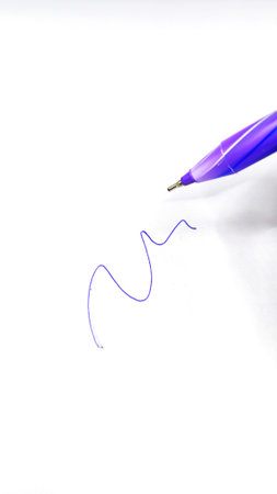 Purple ballpoint pen with cap on white backgroundの写真素材