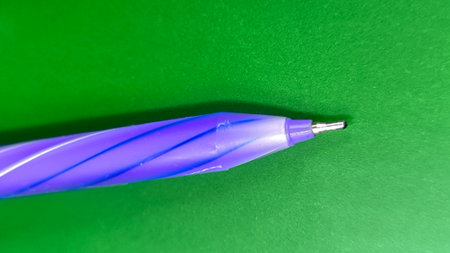 Macro shot of purple ballpoint pen tip on green backgroundの写真素材
