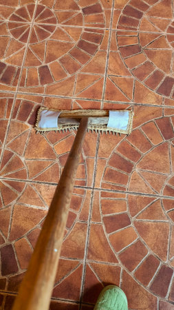 Person Cleaning Tiled Floor with Mop in Residential Interior Close Up View