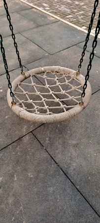 Empty Round Net Nest Swing Hanging on Chains at Outdoor Children Playground