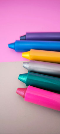 Row of colorful felt tip marker caps on white background. Close up perspective of multicolored pen...