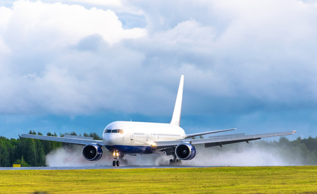 Airplane takes off at the airport rain splashes bad weatherの写真素材