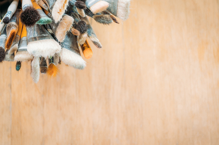 Bunch of old artist paintbrushes on wooden rustic table with space for text.の写真素材