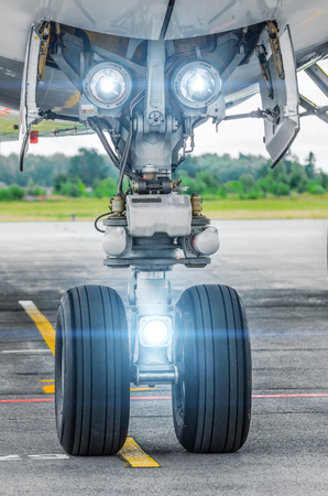 Aircraft landing gear and landing lights lights on.の写真素材