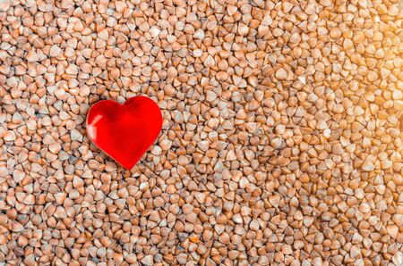 Healthy food, buckwheat groats background and heart symbol.の写真素材