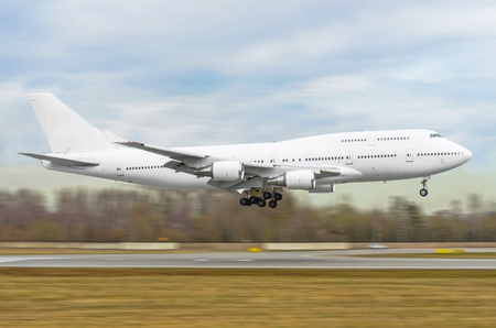 Big white passenger airplane is landing to runway of airportの写真素材