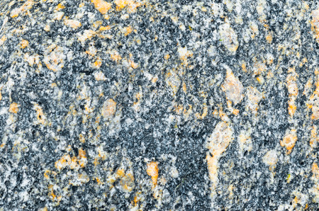 Texture of natural granite, black with yellow-orange impregnation