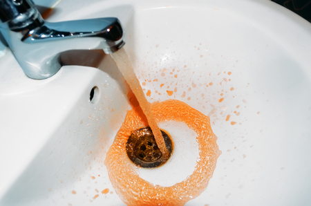 Rust flowing from the tap in the bathroom. Concept of the problem is dirty waterの写真素材