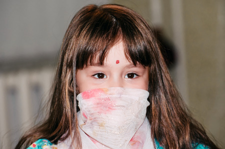 Little caucasian girl dressed in a shawl dances Indian dancesの写真素材