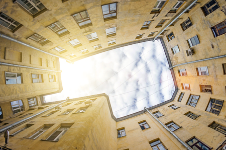 Rectangular closed yard old houses wells in St. Petersburg sky and light.の写真素材
