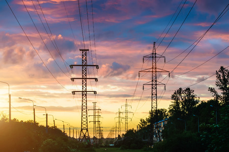 Power lines, sunset evening sky and perspective street in the city