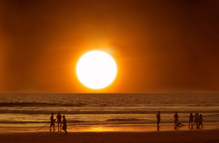 People on the beach in the water at sunset, ocean, vacationの写真素材