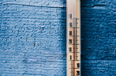 Thermometer on the old wooden wall, concept of hot weather