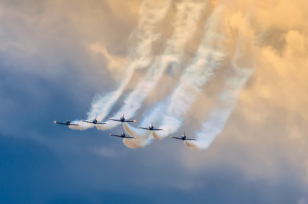 Aerobatic team aircraft fighters trail of smoke in the sky