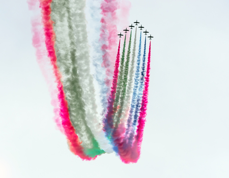 Group of fighter jet airplane with a trace of colorful smoke against sky