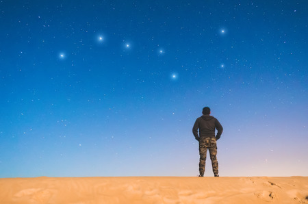 Man at night in the starry sky and sees the constellation The Great Bearの写真素材