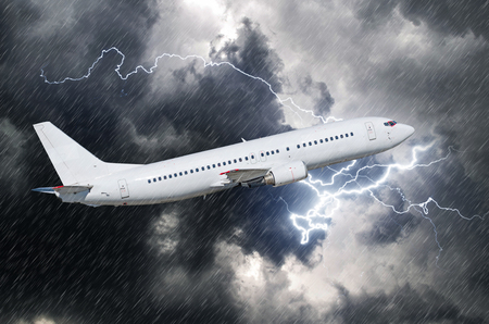 White passenger airplane takes off during a thunderstorm of rain, bad weatherの写真素材