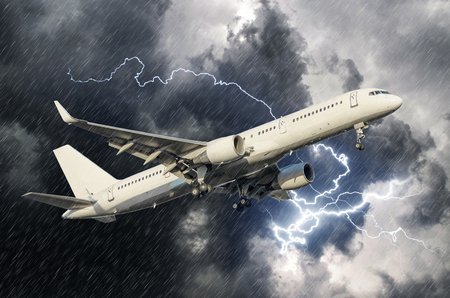 White passenger airplane takes off during a thunderstorm lightning strike of rain, bad weatherの写真素材