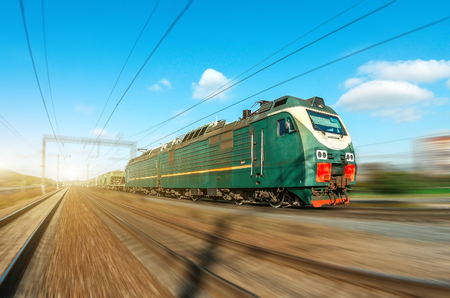 Locomotive electric with a freight train at high speed rides by rail roadの写真素材