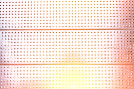Red hot metal plate with holes textureの写真素材