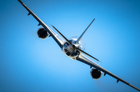 Passenger airplane shiny fuselage and climbing flightの写真素材