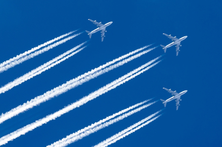 Three Airplane big four engines aviation airport contrail cloudsの写真素材
