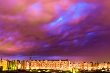 Violet sky clouds after a thunderstorm over the night cityの写真素材