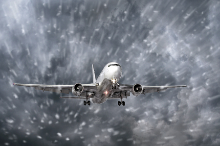 Airplane approaching on a landing in snowstorm bad weatherの写真素材