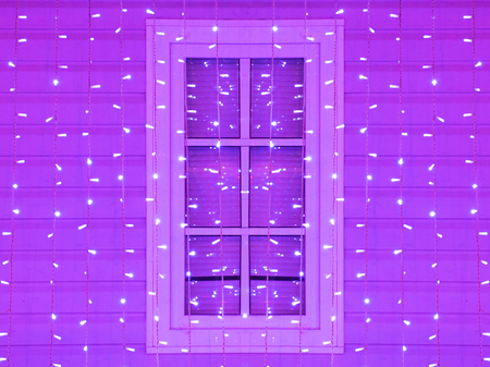 Window of the house decorated with Christmas and Christmas purple lightsの写真素材