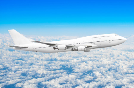 Airplane in the sky above the clouds flight journey sun height.の写真素材
