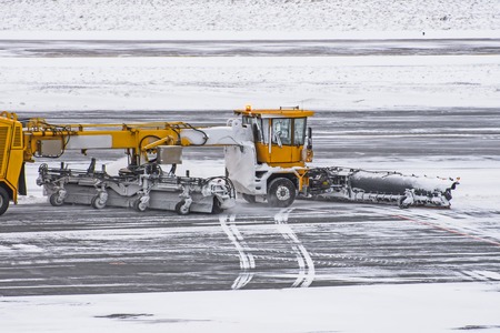 Large snow-plowing machine at work on the road during a snow storm in winter